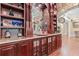 Custom built-in bar with detailed woodwork, granite countertop, and glass shelving at 878 Middle Fork Trl, Suwanee, GA 30024