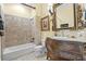 Elegant bathroom featuring a soaking tub, vanity with marble countertop, and decorative mirror at 878 Middle Fork Trl, Suwanee, GA 30024