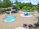 Community pool area with a water park, slides, and lounge chairs at 878 Middle Fork Trl, Suwanee, GA 30024