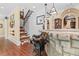 Grand foyer showcasing a beautiful staircase, unique saddle bar stools, and wood flooring at 878 Middle Fork Trl, Suwanee, GA 30024