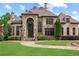 Stately stone home featuring a manicured lawn and stone walkway at 878 Middle Fork Trl, Suwanee, GA 30024