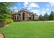 Expansive front lawn and stone exterior on a bright, sunny day at 878 Middle Fork Trl, Suwanee, GA 30024