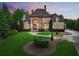 Beautiful stone home with manicured lawn and lush landscaping at sunset at 878 Middle Fork Trl, Suwanee, GA 30024