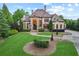 Beautiful stone home with manicured lawn and lush landscaping on a sunny day at 878 Middle Fork Trl, Suwanee, GA 30024