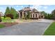 Elegant stone home with a circular driveway and meticulously landscaped grounds at 878 Middle Fork Trl, Suwanee, GA 30024