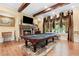 Spacious game room with a pool table, stone fireplace, and abundant natural light at 878 Middle Fork Trl, Suwanee, GA 30024