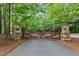 Ornate gate entrance to the property, flanked with stone columns and mature trees at 878 Middle Fork Trl, Suwanee, GA 30024