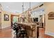 Open concept kitchen features stone accents, dark wood cabinets, and premium appliances at 878 Middle Fork Trl, Suwanee, GA 30024