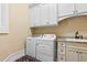 Well-equipped laundry room with sleek appliances, ample cabinet space, and a practical sink area at 878 Middle Fork Trl, Suwanee, GA 30024