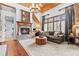 Cozy living room features a stone fireplace, wood floors, comfortable seating, and natural light at 878 Middle Fork Trl, Suwanee, GA 30024