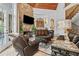 Luxurious living room featuring a stone fireplace, wood ceiling, and French doors at 878 Middle Fork Trl, Suwanee, GA 30024