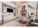 Stylish living room features a stone fireplace, built-in cabinets, mini-bar, and hardwood floors at 878 Middle Fork Trl, Suwanee, GA 30024