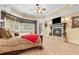 Spacious carpeted primary bedroom featuring a fireplace, tray ceiling, and window at 878 Middle Fork Trl, Suwanee, GA 30024