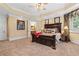 Large primary bedroom featuring a dark wood bed set, a tray ceiling, and carpet at 878 Middle Fork Trl, Suwanee, GA 30024