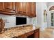 A cozy office space with custom cabinets, granite countertops, under cabinet lighting and a view to the entry at 878 Middle Fork Trl, Suwanee, GA 30024