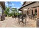 Outdoor patio with stone flooring, dining tables, chairs, and landscape views at 878 Middle Fork Trl, Suwanee, GA 30024