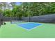 Bright blue pickleball court with green perimeter and net at 878 Middle Fork Trl, Suwanee, GA 30024