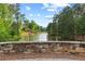 Scenic view of a pond with trees surrounding the bank and a stone bridge in the foreground at 878 Middle Fork Trl, Suwanee, GA 30024
