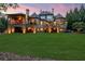 Expansive backyard of an elegant stone home featuring covered patios and lush trees at 878 Middle Fork Trl, Suwanee, GA 30024