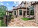 Backyard patio featuring stone flooring, lounge chairs, well-manicured lawn, and brick facade at 878 Middle Fork Trl, Suwanee, GA 30024