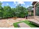 Stone patio with black metal railing, lounge chairs, and green artificial turf for relaxation at 878 Middle Fork Trl, Suwanee, GA 30024