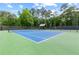 Well-maintained tennis courts with green and blue surface surrounded by trees at 878 Middle Fork Trl, Suwanee, GA 30024