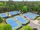 Aerial view showcasing well-maintained tennis courts within a lush, green community at 878 Middle Fork Trl, Suwanee, GA 30024