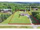 Expansive property with a well-maintained home, surrounded by lush greenery and defined by red property lines at 24 Fossetts Nw Cv, Cartersville, GA 30121