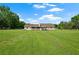View of backyard of a charming ranch home showcasing a well-maintained lawn and mature trees on a sunny day at 24 Fossetts Nw Cv, Cartersville, GA 30121