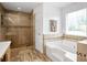 Bright bathroom featuring a glass shower, soaking tub and vanity at 24 Fossetts Nw Cv, Cartersville, GA 30121
