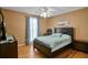 Cozy bedroom featuring a ceiling fan, warm paint, and hardwood floors with a comfortable-looking bed at 24 Fossetts Nw Cv, Cartersville, GA 30121