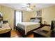 Bright bedroom with a ceiling fan and hardwood floors offering a comfortable bed and a dedicated workspace at 24 Fossetts Nw Cv, Cartersville, GA 30121