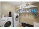 Functional laundry room with washer, dryer, and shelving for organized storage and cleaning supplies at 24 Fossetts Nw Cv, Cartersville, GA 30121