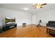 Spacious living room with hardwood floors, featuring a ceiling fan and TV at 24 Fossetts Nw Cv, Cartersville, GA 30121