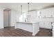 Bright kitchen with white cabinets, central island, dark hardwood floors, and modern appliances at 2733 Creek View Nw Ter, Atlanta, GA 30318