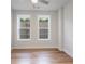 Bedroom with hardwood floors and two windows overlooking the backyard at 1030 Burnside Nw Pl, Atlanta, GA 30318