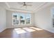 Sunlit bedroom featuring hardwood floors, a tray ceiling, and expansive windows for natural light at 1030 Burnside Nw Pl, Atlanta, GA 30318