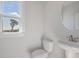 This powder room features a sleek pedestal sink, round mirror and a window with a lovely view at 1030 Burnside Nw Pl, Atlanta, GA 30318