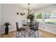Elegant dining area with a modern chandelier, a glass table, and views of the outdoors at 2158 Oregon Ct, Decatur, GA 30032