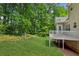 Large backyard featuring a well-manicured lawn and a deck connected to a house with natural views at 3845 Pilgrim Mill Rd, Cumming, GA 30041