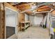 Unfinished basement with workbench, exposed beams, and a doorway to another part of the basement at 3845 Pilgrim Mill Rd, Cumming, GA 30041