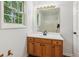 Well-lit bathroom vanity with wood cabinets and white countertops beneath a large mirror at 3845 Pilgrim Mill Rd, Cumming, GA 30041