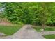 Long driveway leading up to a home that is surrounded by lush greenery and mature trees at 3845 Pilgrim Mill Rd, Cumming, GA 30041