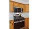 Close-up of kitchen featuring stainless steel gas range, microwave, and wood cabinets at 3845 Pilgrim Mill Rd, Cumming, GA 30041