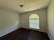 Cozy bedroom featuring dark wood floors, simple ceiling fan and an arched window at 1100 Whistle Dr, Austell, GA 30106