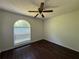 Bright bedroom featuring dark wood floors, ceiling fan and a large arched window at 1100 Whistle Dr, Austell, GA 30106