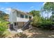Lovely home exterior displaying a spacious backyard with patio, staircase, and mature trees at 1505 Cedar Bluff Trl, Marietta, GA 30062