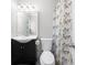 Well-lit bathroom with a modern vanity, toilet, and shower featuring a patterned curtain at 1505 Cedar Bluff Trl, Marietta, GA 30062