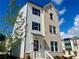 Beautiful three-story home boasts mixed materials, a red door and a manicured lawn at 2731 Stream Valley Lane Nw Nw Cir, Atlanta, GA 30318
