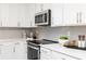 Close-up of a bright, modern kitchen featuring stainless steel appliances and subway tile backsplash at 2731 Stream Valley Lane Nw Nw Cir, Atlanta, GA 30318